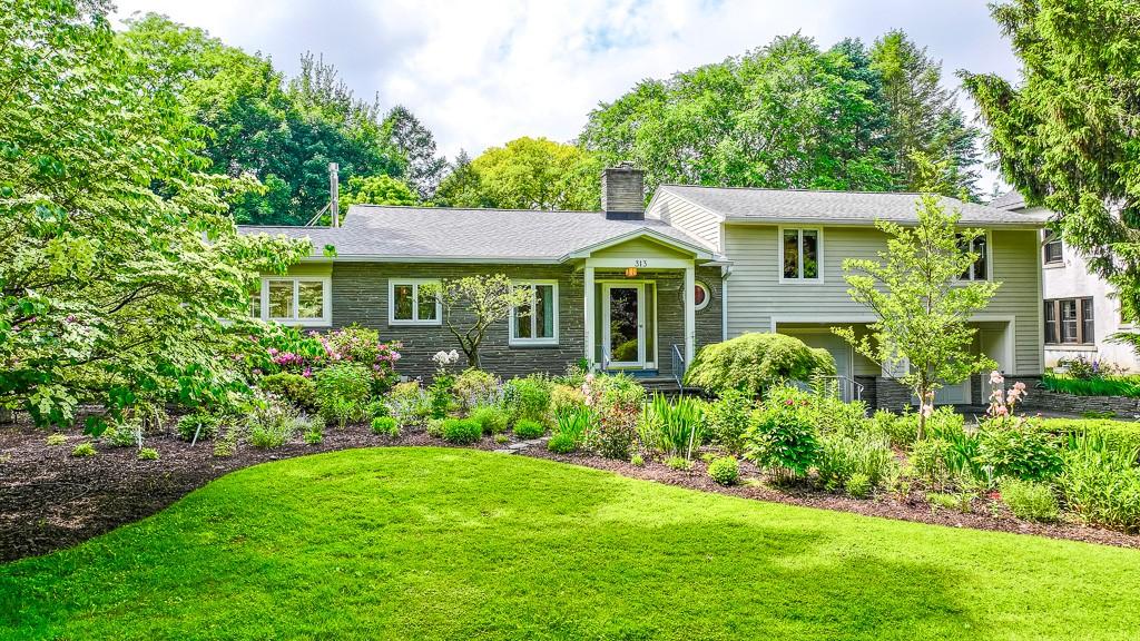 313 Pelham Rd, Brighton, NY 14610 - split level home with a chimney, a front yard, and stone siding