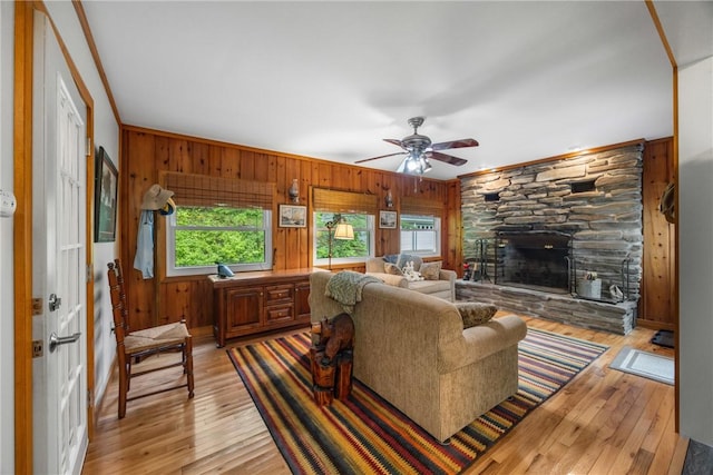 15205 W Lake Rd, Pulteney, NY 14418 - living area with wooden walls, a fireplace, ornamental molding, light wood-style floors, and ceiling fan