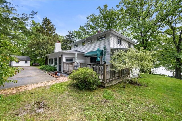 15205 W Lake Rd, Pulteney, NY 14418 - rear view of house with a wooden deck, a chimney, and a lawn