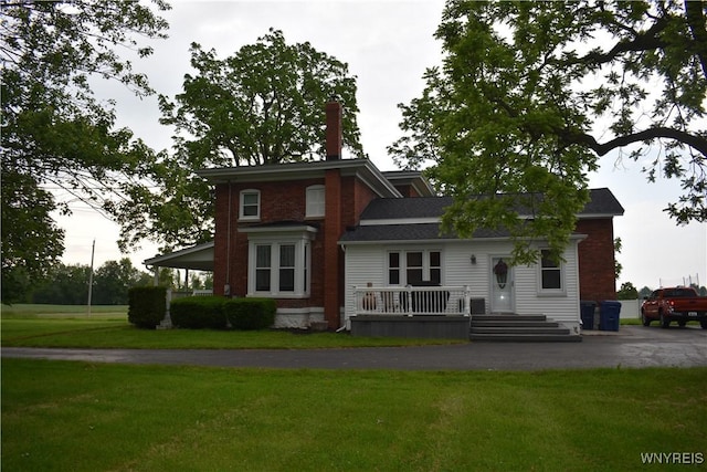 4571 Budd Rd, Cambria, NY 14094 - view of front of home with a chimney, a front lawn, asphalt driveway, and a porch