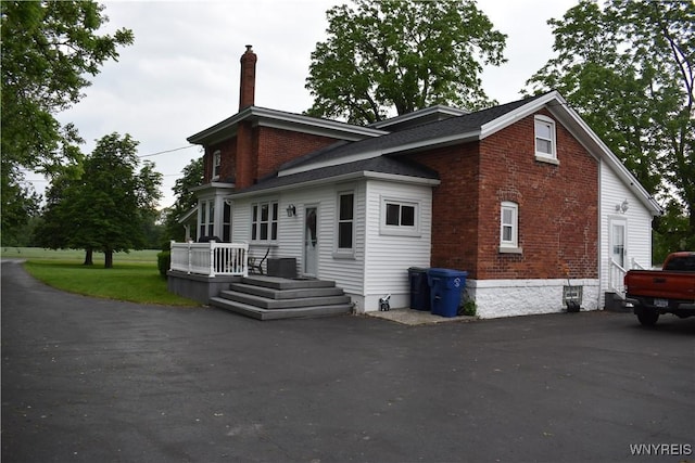 4571 Budd Rd, Cambria, NY 14094 - view of home's exterior featuring a chimney and brick siding