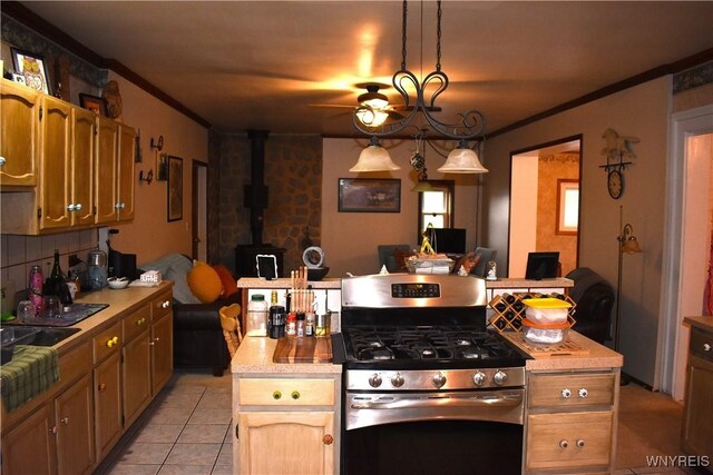 4571 Budd Rd, Cambria, NY 14094 - kitchen featuring gas range, a ceiling fan, light countertops, light tile patterned floors, and a wood stove