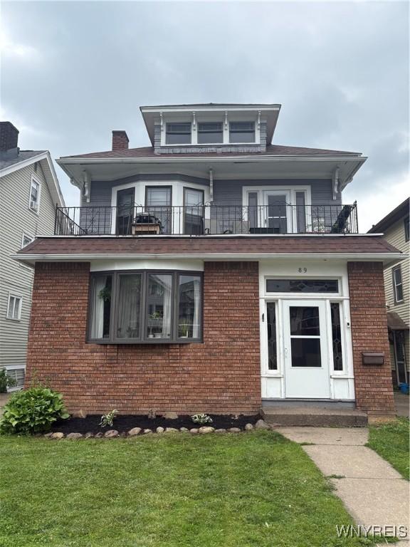 89 Rutland St, Buffalo, NY 14220 - american foursquare style home with a balcony, brick siding, and a front lawn
