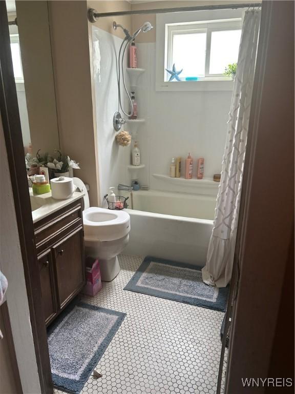 89 Rutland St, Buffalo, NY 14220 - bathroom featuring vanity, shower / tub combo with curtain, toilet, and tile patterned floors