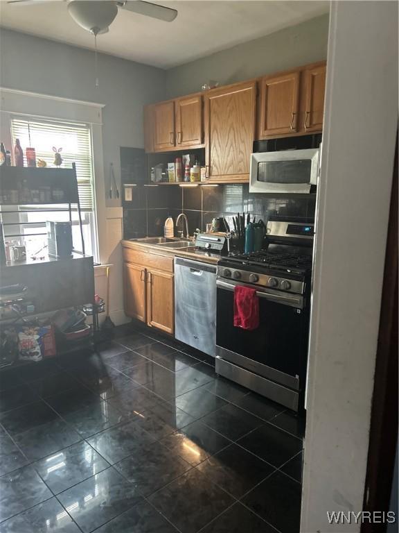 89 Rutland St, Buffalo, NY 14220 - kitchen with appliances with stainless steel finishes, decorative backsplash, a sink, brown cabinets, and ceiling fan