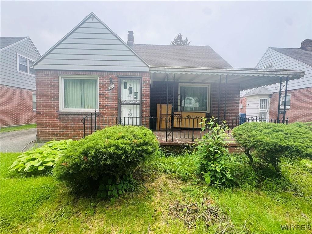 57 Erskine Ave, Buffalo, NY 14215 - bungalow-style house with brick siding, a chimney, and covered porch