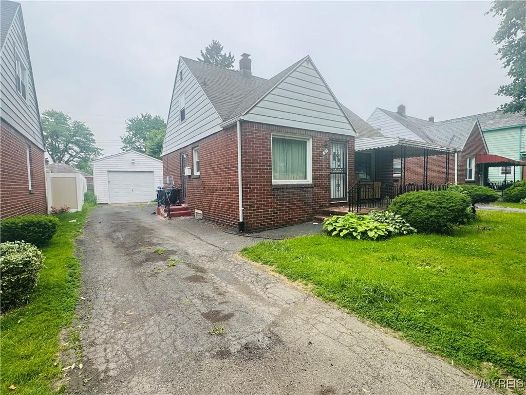 57 Erskine Ave, Buffalo, NY 14215 - bungalow-style house featuring brick siding, asphalt driveway, an outdoor structure, a garage, and a chimney