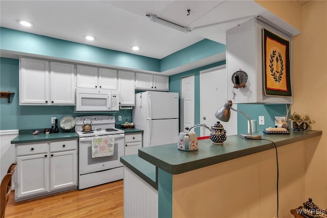 108 Hickory Hill Rd Unit H, Amherst, NY 14221 - kitchen featuring white appliances, dark countertops, a peninsula, light wood-style flooring, and recessed lighting