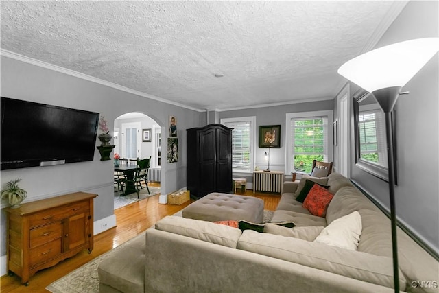 4937 W Seneca, Onondaga, NY 13215 - living area featuring arched walkways, wood finished floors, radiator, a textured ceiling, and ornamental molding