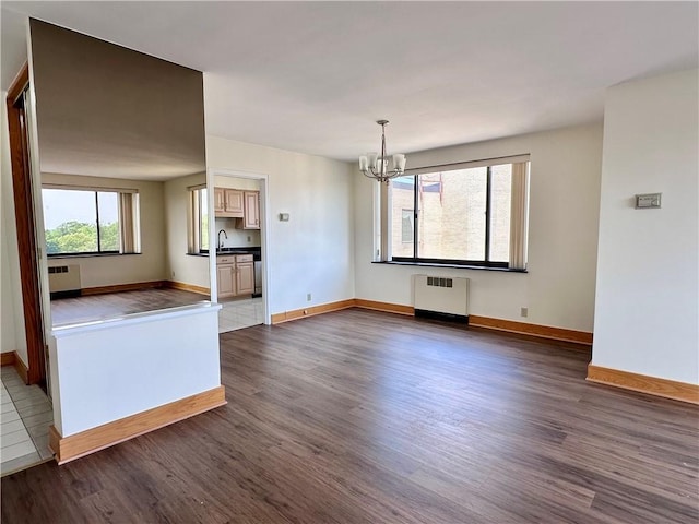 2501 E Ave, Brighton, NY 14610 - unfurnished living room with radiator, a chandelier, and dark wood-type flooring