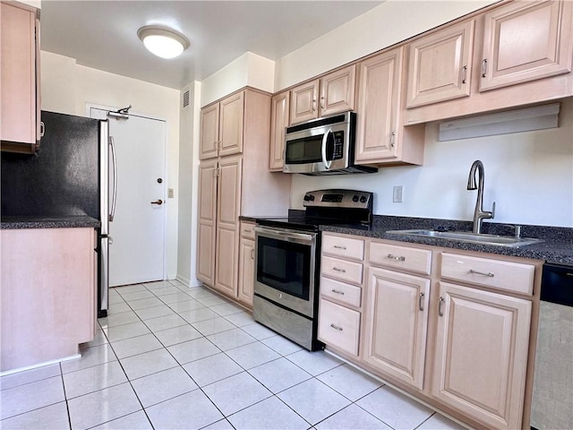 2501 E Ave, Brighton, NY 14610 - kitchen featuring stainless steel appliances, a sink, light tile patterned floors, light brown cabinets, and dark stone countertops