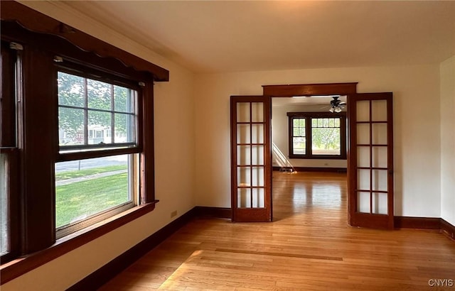 700 Elm St, Rome-Inside, NY 13440 - unfurnished room featuring french doors, light wood-type flooring, baseboards, and a ceiling fan