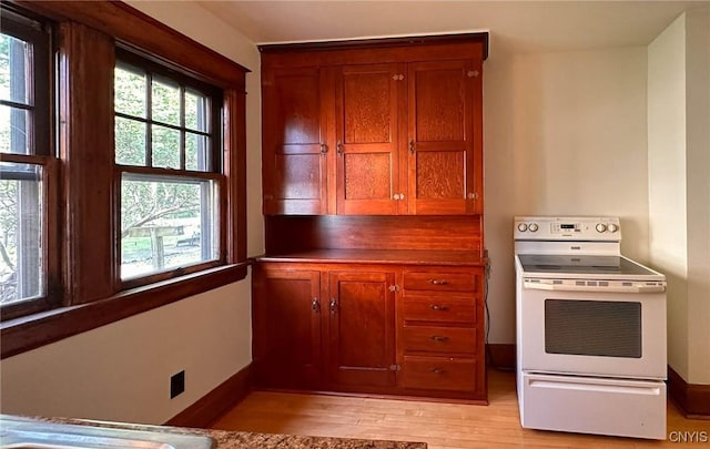 700 Elm St, Rome-Inside, NY 13440 - kitchen with electric stove, light wood-style flooring, baseboards, and brown cabinetry