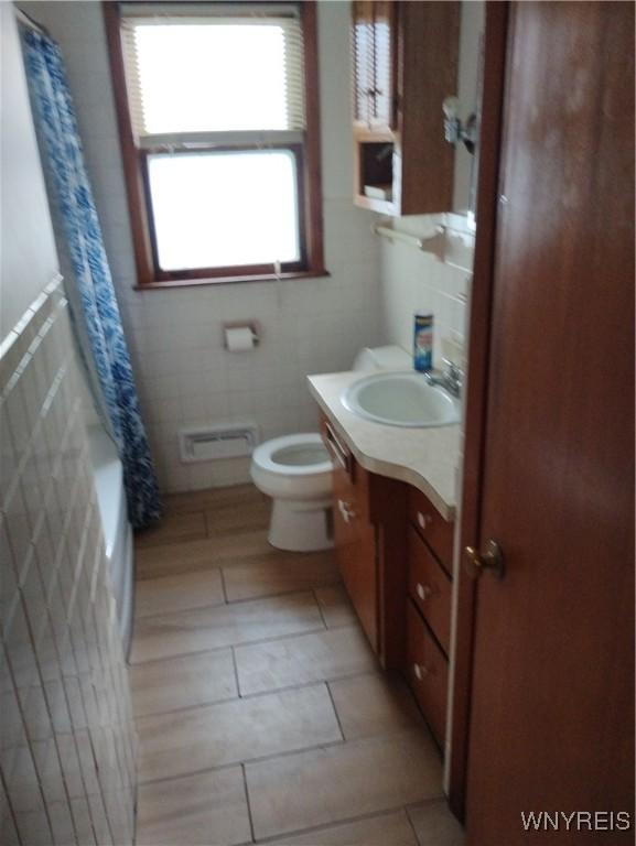 72 Nicholson St, Buffalo, NY 14214 - bathroom featuring tile walls, vanity, and shower / bath combo with shower curtain