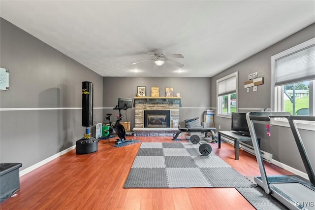 311 Mcintosh Dr, Auburn, NY 13021 - exercise area featuring plenty of natural light, a ceiling fan, wood finished floors, and a stone fireplace