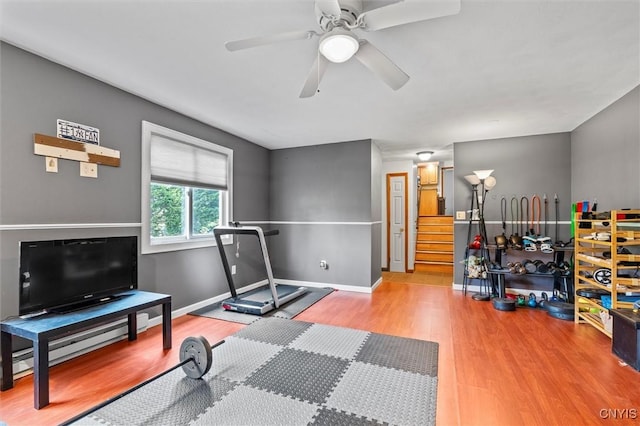 311 Mcintosh Dr, Auburn, NY 13021 - exercise room featuring light wood finished floors, a ceiling fan, baseboards, and baseboard heating