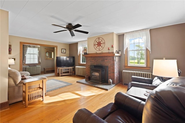 707 Hubbell Rd, Ogden, NY 14428 - living room with radiator, a wood stove, and a ceiling fan