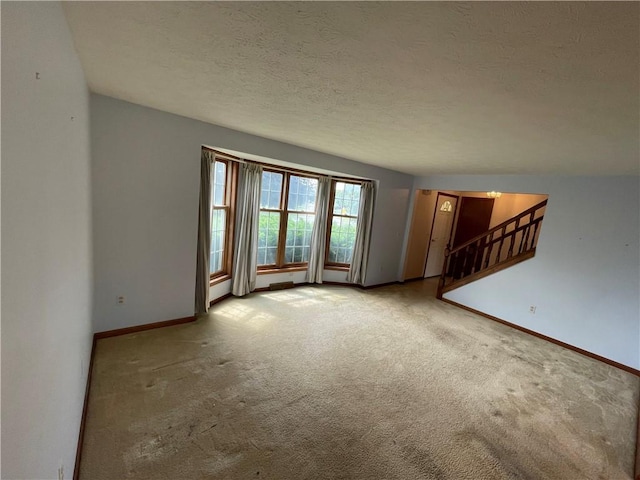 235 Briarwood Ln, Wheatland, NY 14546 - unfurnished living room with carpet, baseboards, stairs, and a textured ceiling