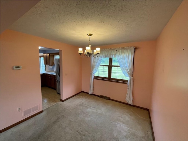 235 Briarwood Ln, Wheatland, NY 14546 - empty room with a chandelier, a textured ceiling, light colored carpet, and baseboards