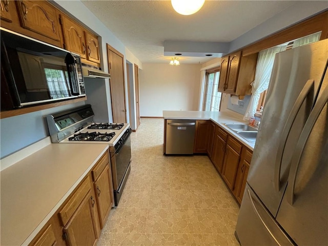235 Briarwood Ln, Wheatland, NY 14546 - kitchen with appliances with stainless steel finishes, brown cabinets, light countertops, under cabinet range hood, and light flooring