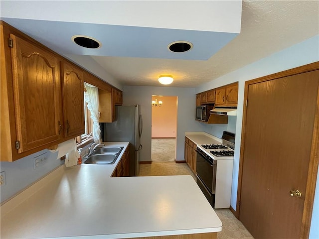 235 Briarwood Ln, Wheatland, NY 14546 - kitchen with gas range oven, under cabinet range hood, freestanding refrigerator, brown cabinetry, and baseboards