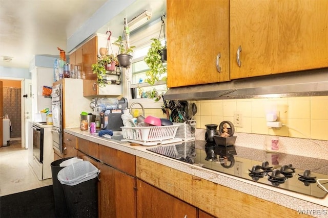 596 Longmeadow Rd, Amherst, NY 14226 - kitchen featuring brown cabinets, light countertops, range with electric stovetop, backsplash, and black electric stovetop