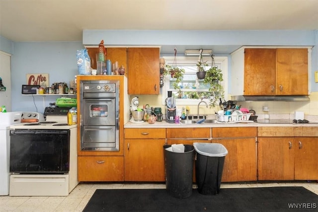 596 Longmeadow Rd, Amherst, NY 14226 - kitchen featuring oven, a warming drawer, light countertops, brown cabinetry, and backsplash