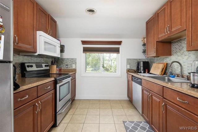 596 Longmeadow Rd, Amherst, NY 14226 - kitchen featuring stainless steel appliances, a sink, tasteful backsplash, baseboards, and light countertops