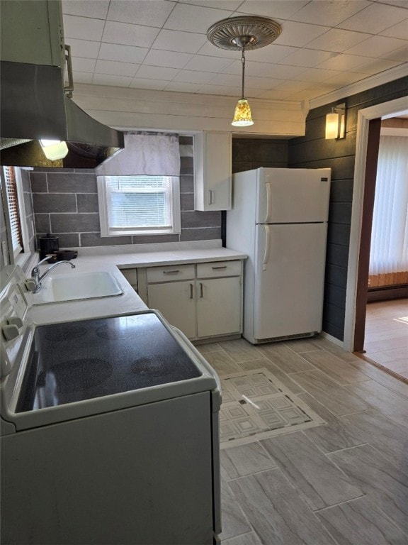 30 Park Ave, Eldred, PA 16731 - kitchen with freestanding refrigerator, a sink, range, wooden walls, and hanging light fixtures