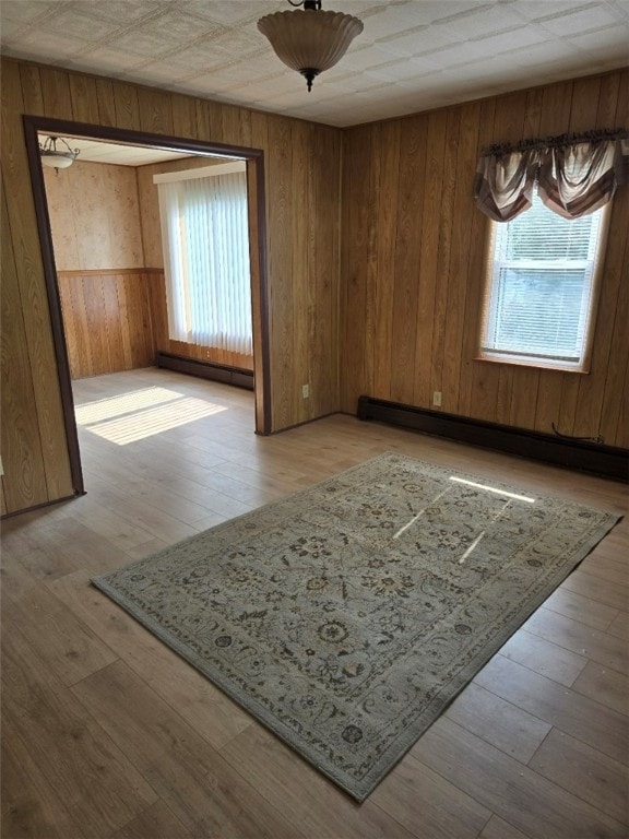 30 Park Ave, Eldred, PA 16731 - empty room featuring wooden walls, baseboard heating, a baseboard radiator, and wood-type flooring