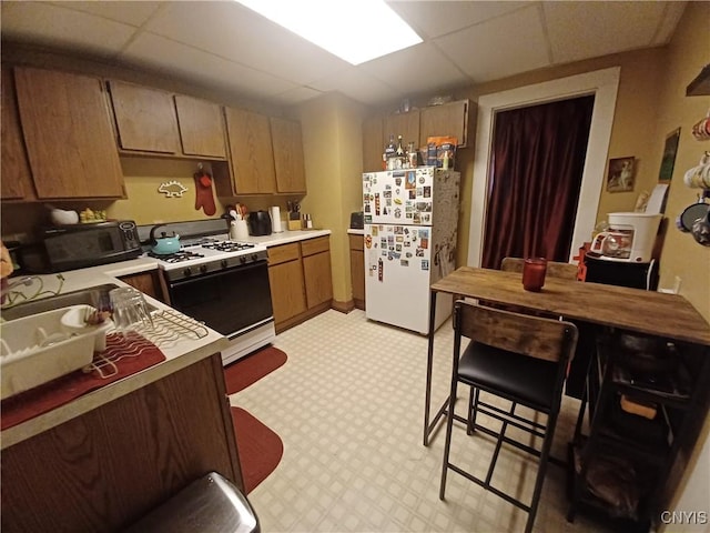 58-60 Lansing St, Auburn, NY 13021 - kitchen with white appliances, a drop ceiling, and light countertops