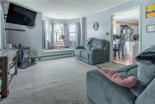 18916 State Route 3, Hounsfield, NY 13601 - living area with a wood stove, a baseboard radiator, ornamental molding, ceiling fan, and carpet