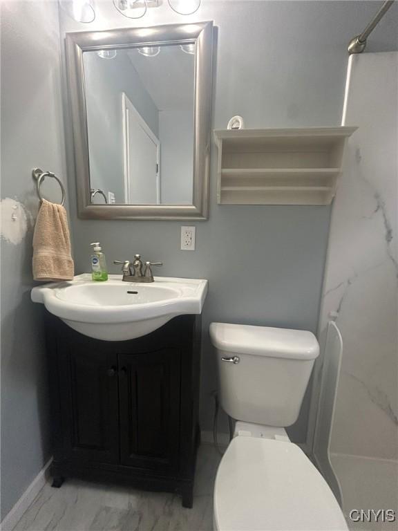 719 Dawes Ave, Utica, NY 13502 - bathroom with marble finish floors, a shower, vanity, and toilet