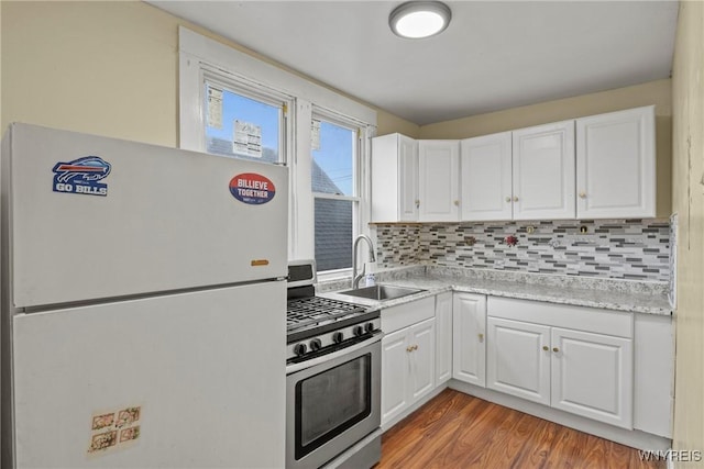 159 Kilhoffer St, Buffalo, NY 14211 - kitchen with freestanding refrigerator, gas stove, a sink, and white cabinetry