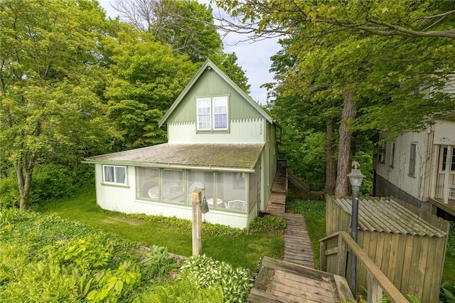 7732 Lake Blf, Huron, NY 14590 - view of front of house featuring a sunroom, stairs, and a shingled roof