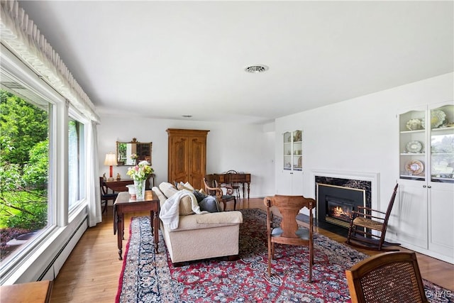 139 Capitol Street Ext, Sennett, NY 13021 - living room featuring a baseboard radiator, a high end fireplace, and wood finished floors