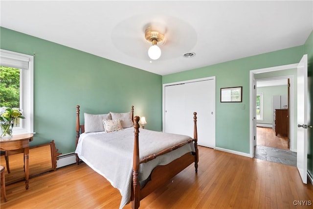 139 Capitol Street Ext, Sennett, NY 13021 - bedroom with light wood-type flooring, a baseboard radiator, a closet, and ceiling fan