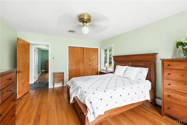 139 Capitol Street Ext, Sennett, NY 13021 - bedroom with wood finished floors, a closet, a ceiling fan, a baseboard radiator, and baseboards