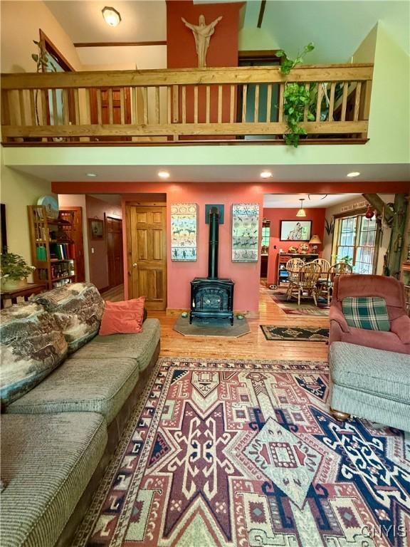 3805 State Highway 80, Columbus, NY 13460 - living room featuring a wood stove, a towering ceiling, and wood finished floors