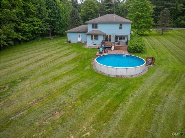 3871 Skyline Dr, Kirkland, NY 13323 - back of property with a wooden deck, an outdoor pool, a yard, and roof with shingles
