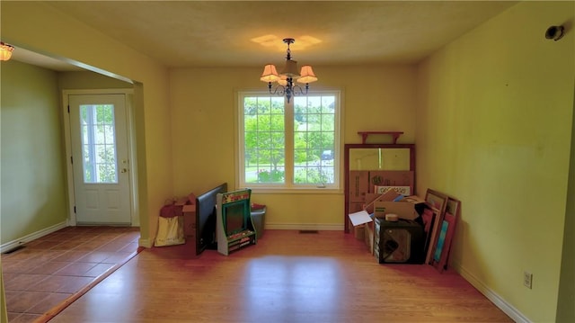 1547 Great Gully Rd, Springport, NY 13160 - dining space featuring a chandelier, healthy amount of natural light, wood finished floors, and baseboards