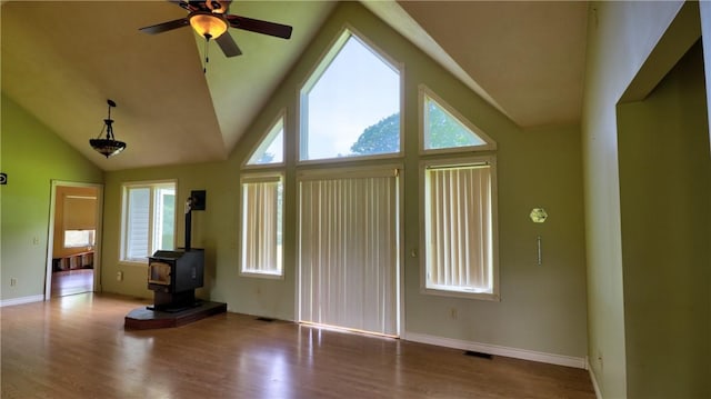 1547 Great Gully Rd, Springport, NY 13160 - entryway featuring a wood stove, ceiling fan, wood finished floors, baseboards, and high vaulted ceiling