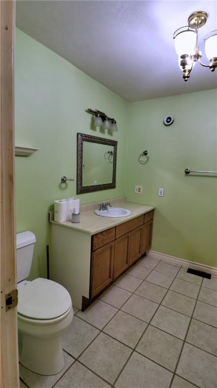 1547 Great Gully Rd, Springport, NY 13160 - bathroom with tile patterned flooring, vanity, toilet, and a chandelier