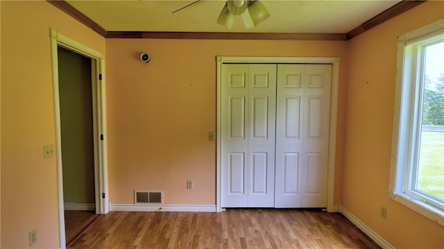 1547 Great Gully Rd, Springport, NY 13160 - unfurnished bedroom with light wood-style flooring, a closet, baseboards, multiple windows, and ornamental molding