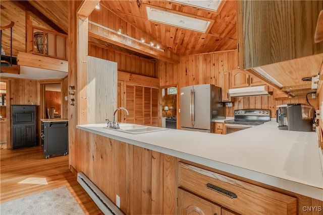 48785 Bamerick Rd, Alexandria, NY 13679 - kitchen with stainless steel appliances, under cabinet range hood, a skylight, a sink, and wood walls
