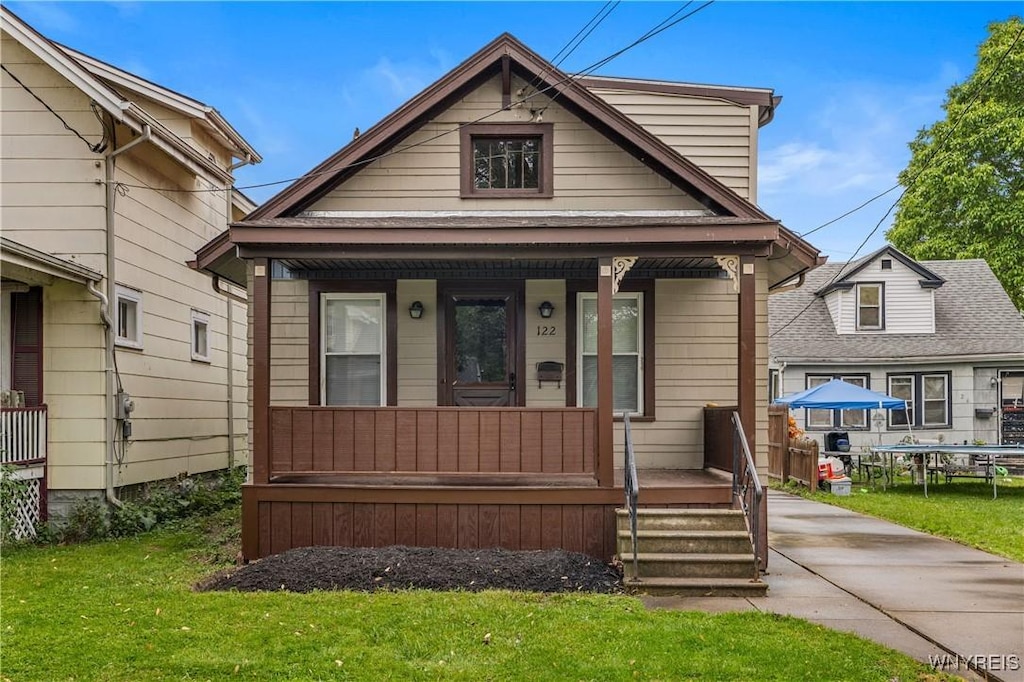 122 69th St, Niagara Falls, NY 14304 - shotgun-style home featuring covered porch and a front yard
