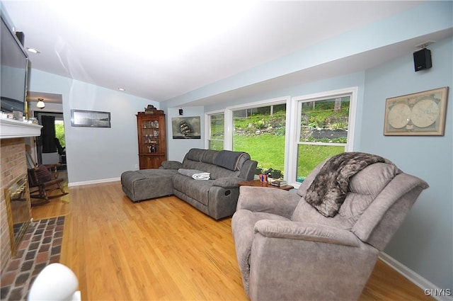 4648 Glencliffe Rd, Manlius, NY 13104 - living room with wood finished floors, a brick fireplace, vaulted ceiling, baseboards, and recessed lighting