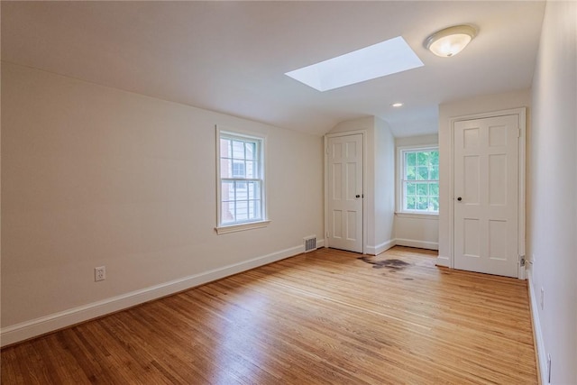 68 Colonial Village Rd, Brighton, NY 14625 - unfurnished room with a skylight, light wood finished floors, baseboards, and vaulted ceiling