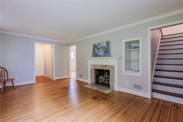68 Colonial Village Rd, Brighton, NY 14625 - unfurnished living room with stairway, a tile fireplace, built in shelves, light wood-type flooring, and crown molding