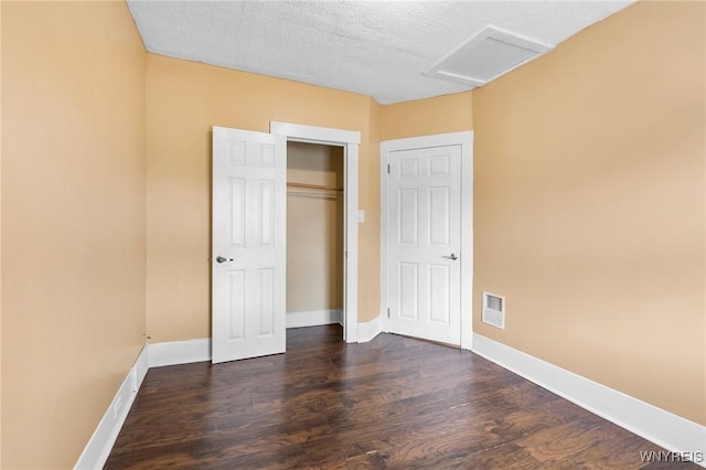 103 Ledger St, Buffalo, NY 14216 - unfurnished bedroom featuring dark wood-style floors, attic access, baseboards, a closet, and a textured ceiling